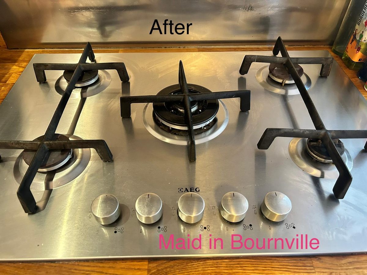 The same five-burner range hob wiped clean and polished after cleaning
