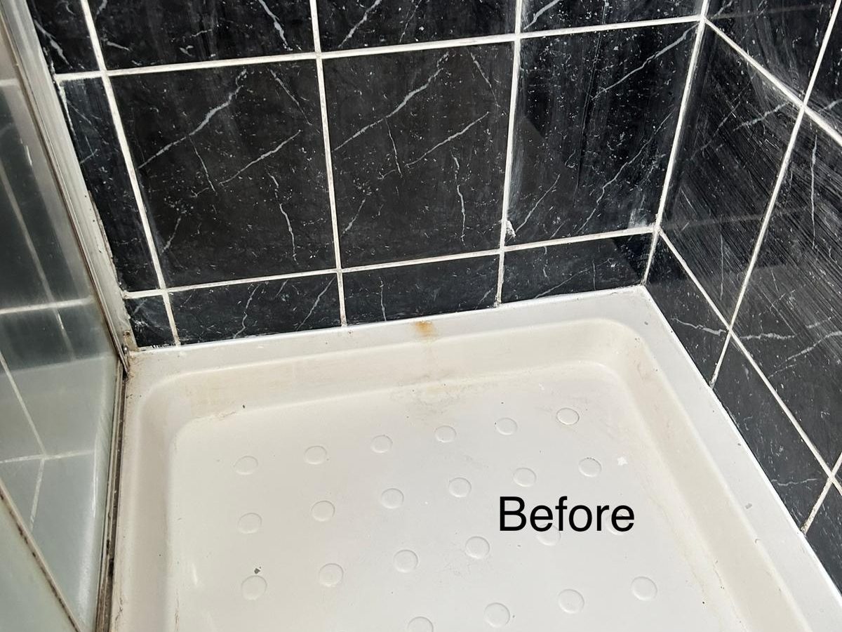 Shower tray with staining and grubby grout before cleaning