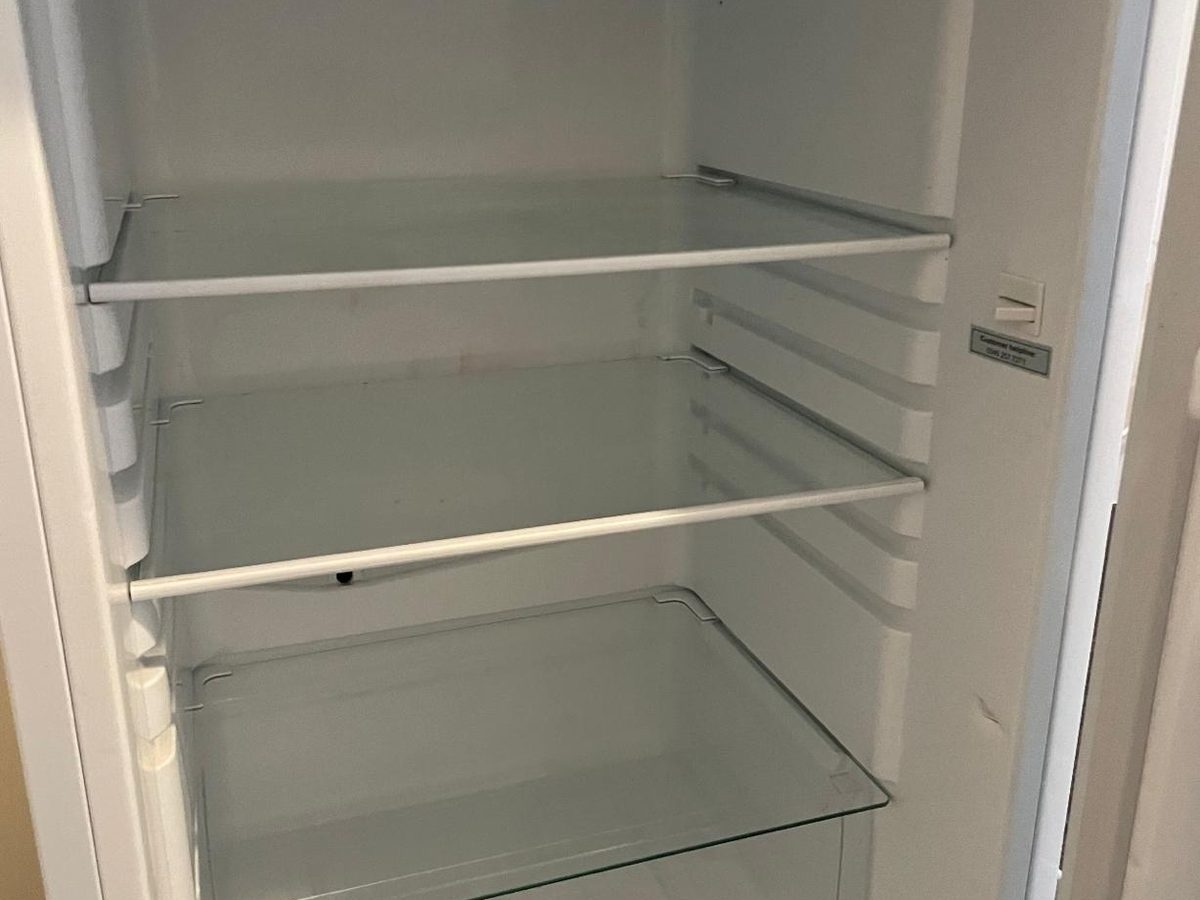 The same fridge interior clean with clear shelves after cleaning