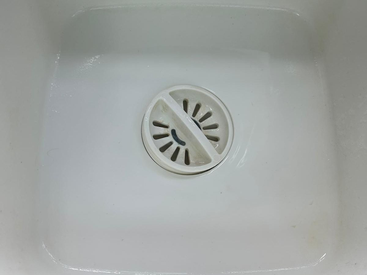 The same white sink bowl clean and bright after cleaning