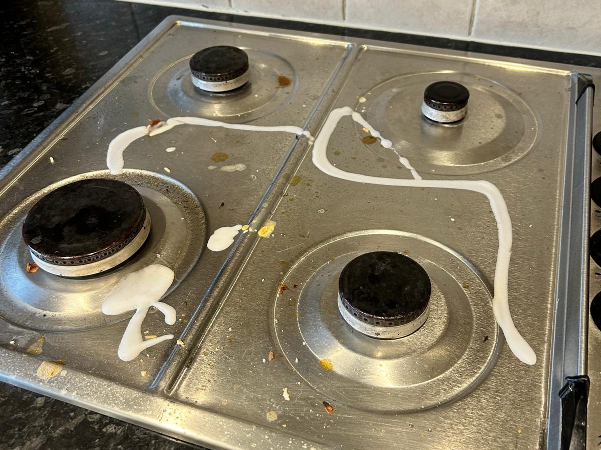 Hob top covered in spilled sauce and food bits before cleaning