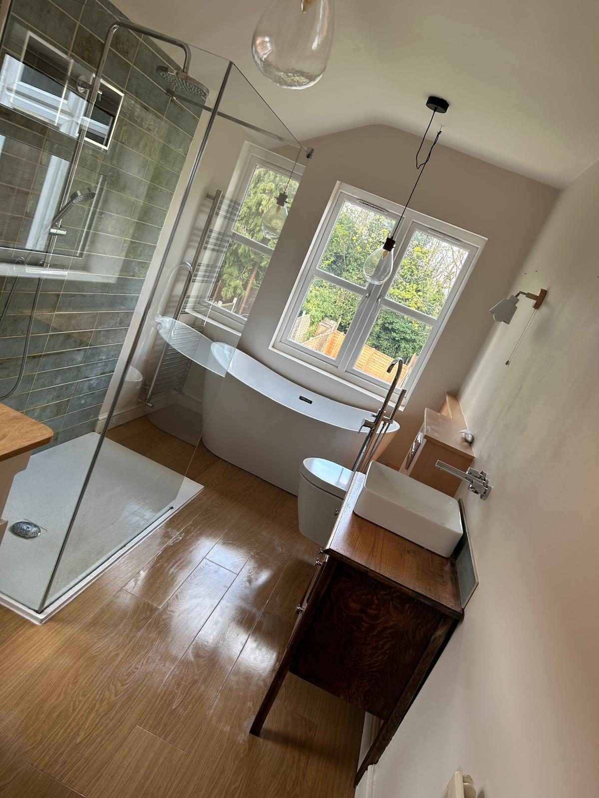 Bathroom with walk-in shower and freestanding bath after a clean by Maid in Bournville