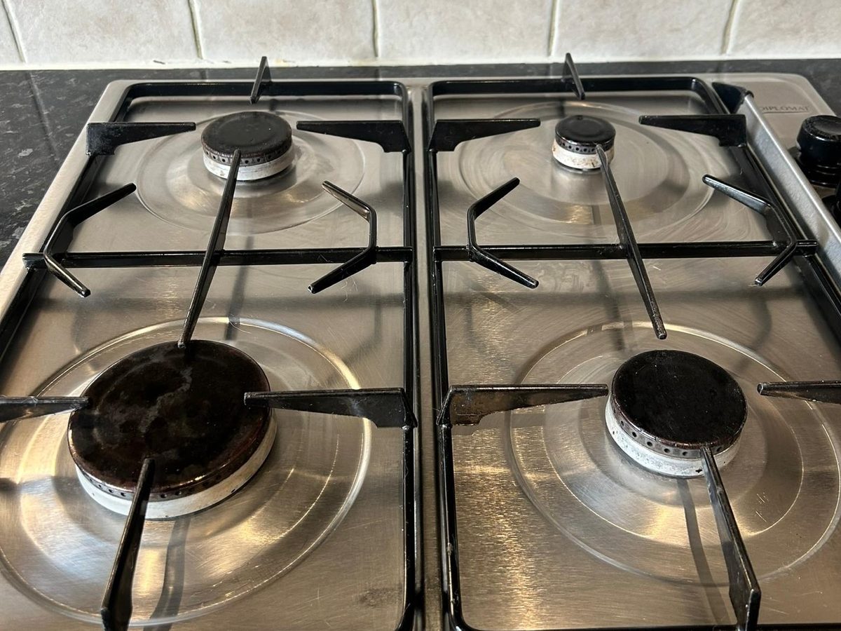 The same gas hob with clean burners and polished stainless steel after cleaning