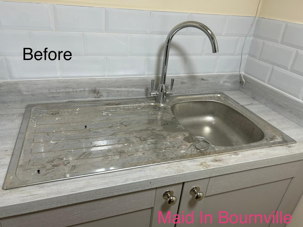 Kitchen sink and drainer covered in dust and plaster residue before cleaning
