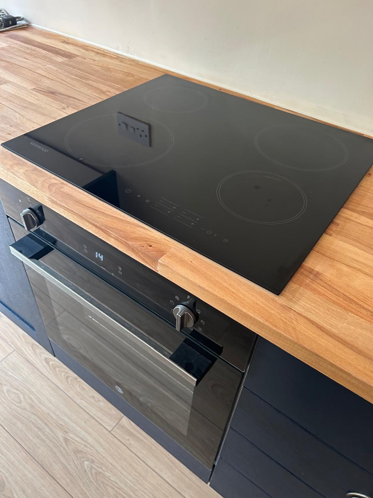 Induction hob and built-in oven front after a kitchen clean by Maid in Bournville