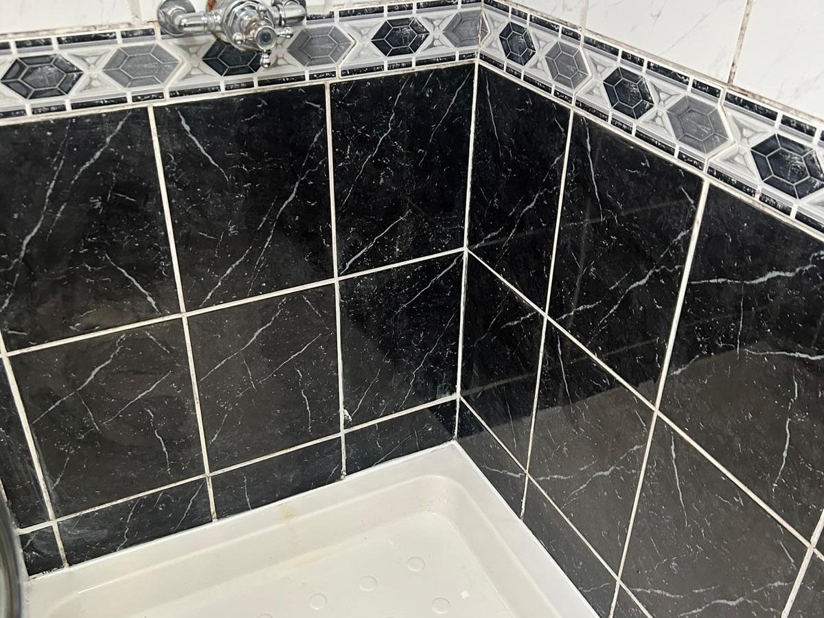 The same shower tray white and tiles gleaming after cleaning